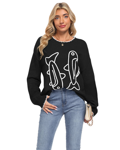 Model wearing an AUSELILY black sardine sweater with white cord embroidered fish and scalloped neckline and cuffs