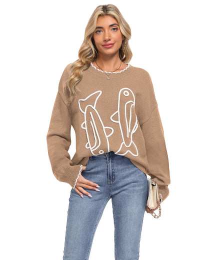 Model wearing an AUSELILY khaki sardine sweater with white cord embroidered fish and scalloped neckline and cuffs